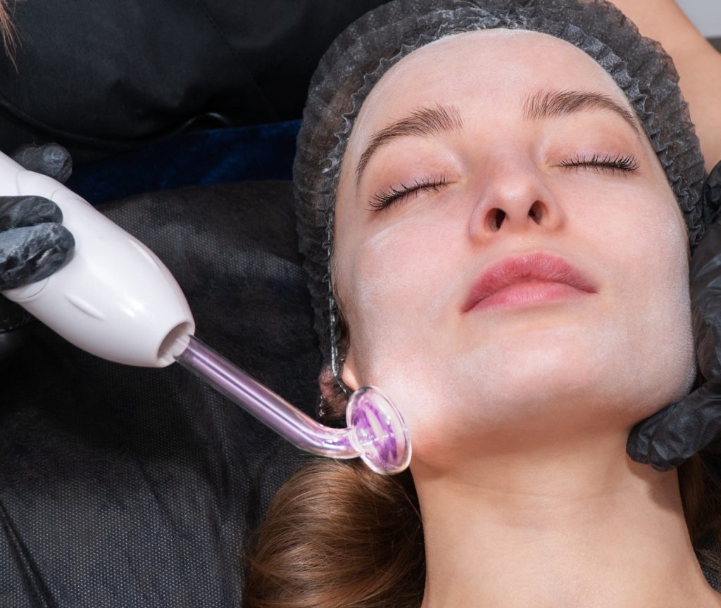 Aparato de alta frecuencia para tratamientos faciales mostrando sus beneficios principales en estética.