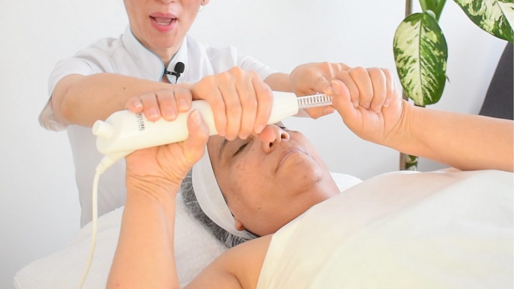 Clienta sujetando el electrodo de fulguración correctamente antes de iniciar el masaje.