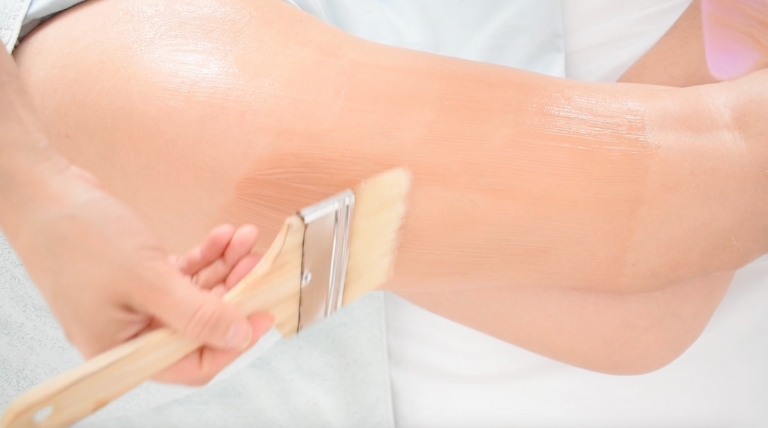 Mascarilla de chocolate aplicada durante tratamiento corporal anticelulitis.
