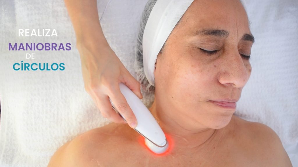 Cosmetóloga profesional aplicando microestimulación facial a clienta.