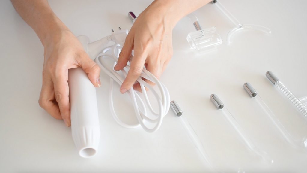 Aparato de alta frecuencia estética con electrodos para tratamientos faciales y corporales.