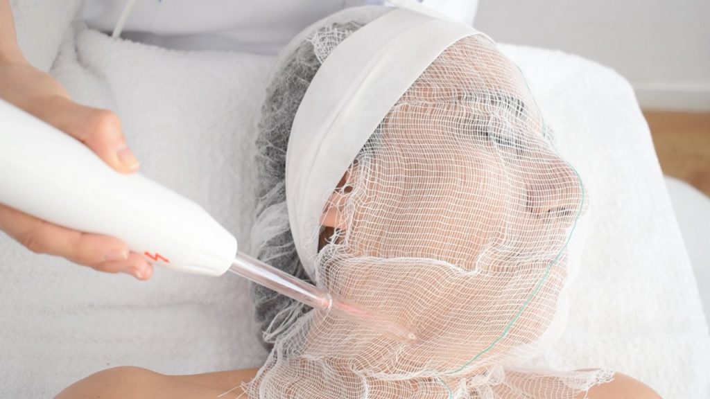 Aplicación de alta frecuencia facial en rostro y cuello para descongestionar la piel.