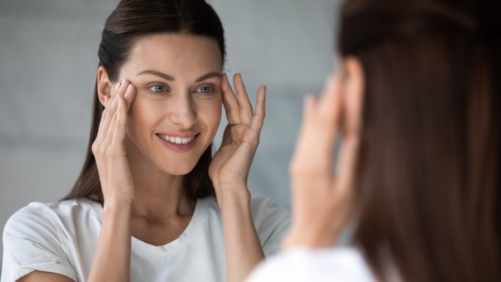Mujer observando su piel más firme y rejuvenecida tras tratamiento con radiofrecuencia facial.