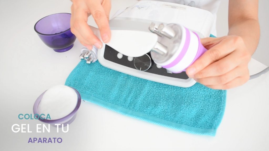 Preparación del equipo de radiofrecuencia corporal aplicando gel conductor en el maneral antes del tratamiento