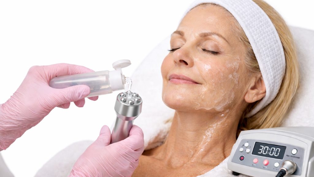 Aplicación de gel conductor en equipo de radiofrecuencia facial antes del tratamiento lifting