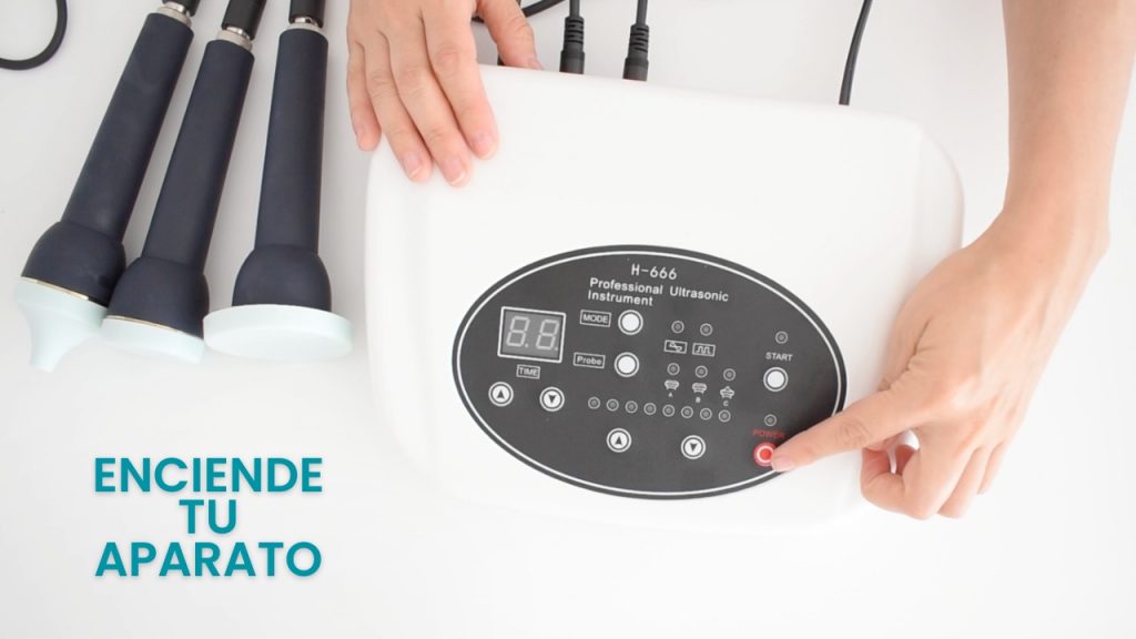 Mano encendiendo equipo de ultrasonido estético en cabina profesional.