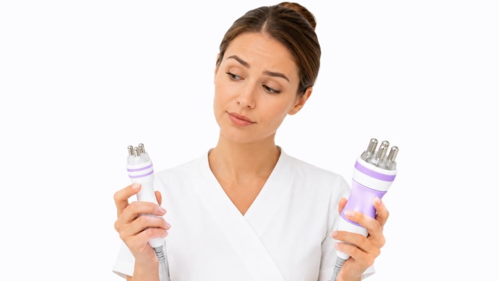 Cosmetóloga comparando el maneral facial de tres polos con el maneral corporal de cuatro polos.